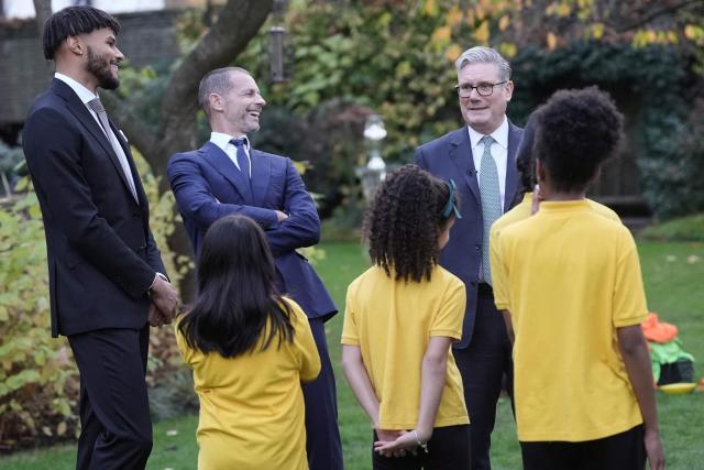 Britain's Prime Minister Keir Starmer (R), UEFA president Aleksander Ceferin (2nd L) and England football player Tyrone Mings (L) chat with children from "John Keble C of E" primary school at 10 Downing Street in London on November 12, 2025, during a visit by UEFA officials to mark the launch of UEFA Euro 2028. The UEFA Euro 2028 tournament is set to be jointly hosted by the United Kingdom and Ireland. (Photo by Stefan Rousseau / POOL / AFP)