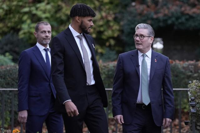 Britain's Prime Minister Keir Starmer (R) welcomes UEFA president Aleksander Ceferin (back L) and England football player Tyrone Mings (C) at 10 Downing Street in London on November 12, 2025, during a visit by UEFA officials to mark the launch of UEFA Euro 2028. The UEFA Euro 2028 tournament is set to be jointly hosted by the United Kingdom and Ireland. (Photo by Stefan Rousseau / POOL / AFP)