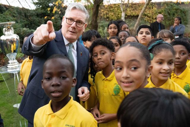 Britain's Prime Minister Keir Starmer (L) meets children from "John Keble C of E" primary school at 10 Downing Street in London on November 12, 2025, during a visit by UEFA officials to mark the launch of UEFA Euro 2028. The UEFA Euro 2028 tournament is set to be jointly hosted by the United Kingdom and Ireland. (Photo by Stefan Rousseau / POOL / AFP)