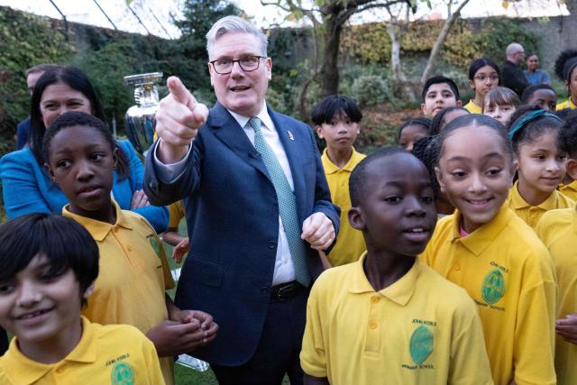 Britain's Prime Minister Keir Starmer (L) and Culture Secretary Lisa Nandy (back L) meet children from "John Keble C of E" primary school at 10 Downing Street in London on November 12, 2025, during a visit by UEFA officials to mark the launch of UEFA Euro 2028. The UEFA Euro 2028 tournament is set to be jointly hosted by the United Kingdom and Ireland. (Photo by Stefan Rousseau / POOL / AFP)