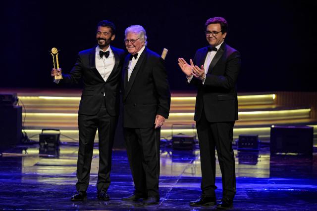 Egyptian actor Khaled al-Nabawy (L) receives a honour award from Egyptian Minister of Culture Ahmed Fouad Hano (R) and president of the Cairo International Film Festival Hussein Fahmi (C) during the opening ceremony of the 46th Cairo International Film Festival (CIFF) in Cairo on November 12, 2025. (Photo by Khaled DESOUKI / AFP)