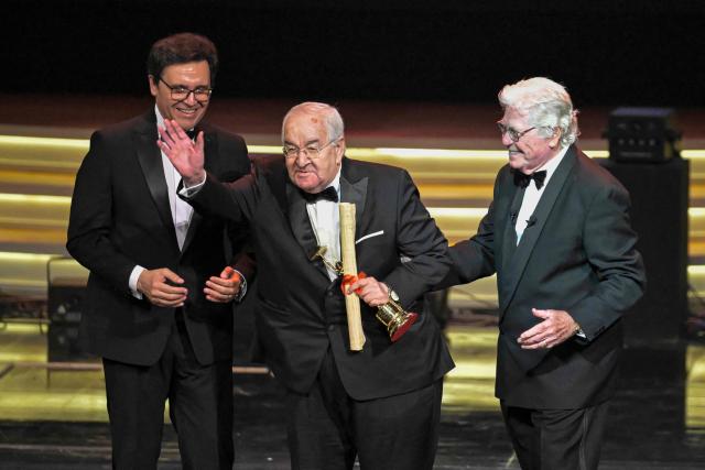 Egyptian director Mohamed Abdelaziz (C) receives a Life Achievement award from Egyptian Minister of Culture Ahmed Fouad Hano (L) and president of the Cairo International Film Festival Hussein Fahmi (R) during the opening ceremony of the 46th Cairo International Film Festival (CIFF) in Cairo on November 12, 2025. (Photo by Khaled DESOUKI / AFP)