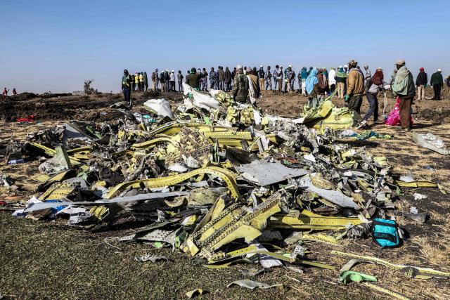 (FILES) People stand near collected debris at the crash site of Ethiopia Airlines near Bishoftu, a town some 60 kilometres southeast of Addis Ababa, Ethiopia, on March 11, 2019. A US jury in the first civil trial over a fatal Boeing 737 MAX crash determined on November 12, 2025 that the aircraft manufacturing giant owes $28.45 million to the family of a newly-wed Indian victim. The case involves the survivors of Shikha Garg of New Delhi, who died in the March 2019 Ethiopian Airlines crash. The Chicago trial in federal court began on November 3. (Photo by Michael TEWELDE / AFP)