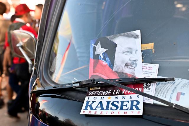A flyer of Chile's presidential candidate Johannes Kaiser of the Libertarian National Party is seen on the windshield of a car ahead of his closing campaign rally in Santiago on November 12, 2025. (Photo by Victor RUIZ / AFP)