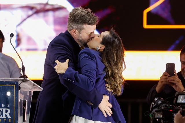 Chile's presidential candidate Johannes Kaiser (L) of the Libertarian National Party kisses his wife Ivette Avaria Vera during his closing campaign rally in Santiago on November 12, 2025. (Photo by Raul BRAVO / AFP)