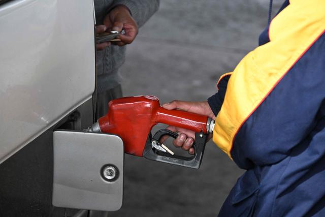 A gas station worker refuels a vehicle in La Paz on November 12, 2025. Lines of cars and buses waiting to refuel at gas stations begin to shrink in Bolivia after more than two years of shortages, following measures by the new government of Rodrigo Paz. (Photo by Aizar RALDES / AFP)