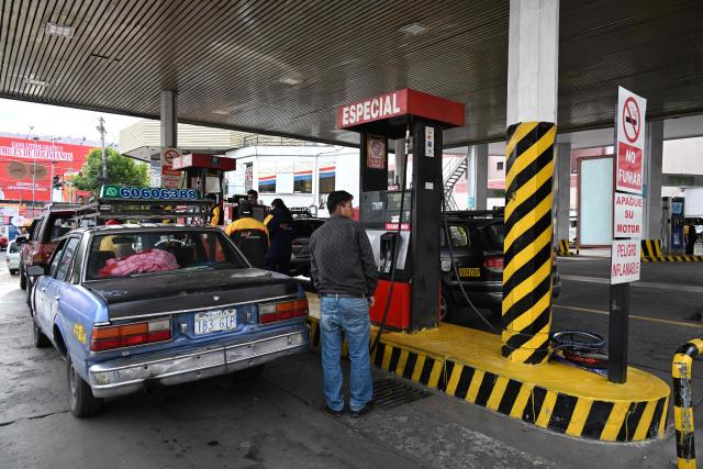 A driver waits to refuel at a gas station in La Paz on November 12, 2025. Lines of cars and buses waiting to refuel at gas stations begin to shrink in Bolivia after more than two years of shortages, following measures by the new government of Rodrigo Paz. (Photo by Aizar RALDES / AFP)