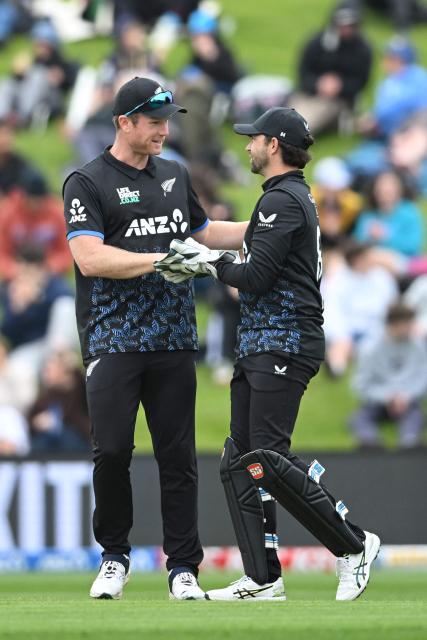 New Zealand's Devon Conway (R) is congratulated by his teammate James Neesham after taking the catch to dismiss West Indies' Shai Hope during the fifth and final Twenty20 international cricket match between New Zealand and West Indies at University of Otago Oval in Dunedin on November 13, 2025. (Photo by Sanka VIDANAGAMA / AFP)