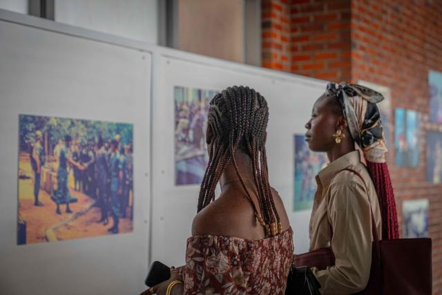 Two students look at photos from the exhibition ‘Mobutu, a life, a destiny’ at the National Museum in Kinshasa, on October 17, 2025. Almost thirty years after the fall of Mobutu Sese Seko, an exhibition dedicated to the former president of Zaire (now the Democratic Republic of Congo, DRC) is generating keen interest among young Congolese born after 1997. Entitled ‘Mobutu, a life, a destiny’, the exhibition, organised by the family of the former president of the Republic, presents personal items, photographs and other archival documents. (Photo by Glody MURHABAZI / AFP)