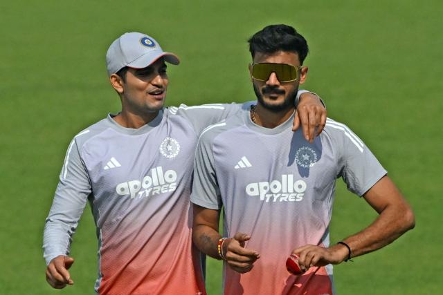India’s captain Shubman Gill (L) and teammate Axar Patel interact during a practice session on the eve of their first Test cricket match against South Africa, at the Eden Gardens in Kolkata on November 13, 2025. (Photo by DIBYANGSHU SARKAR / AFP)