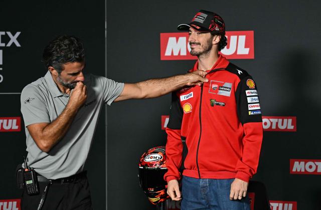 A technician mics Ducati Lenovo Team's Italian MotoGP rider Francesco Bagnaia (R) prior to a press conference at the Ricardo Tormo racetrack in Cheste on November 13, 2025, ahead of the MotoGP Valencia Grand Prix. (Photo by Javier SORIANO / AFP)