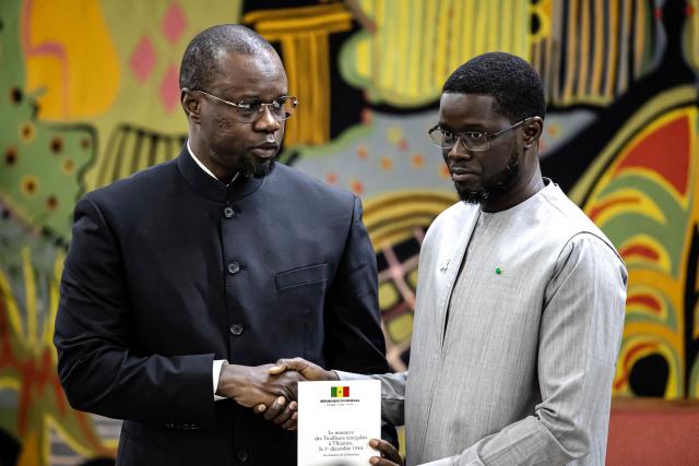 (FILES) Senegal Prime Minister Ousmane Sonko (L) hands over to Senegal President Bassirou Diomaye Faye (R) the official report on the Thiaroye massacre during a ceremony at the Presidential Palace in Dakar, on October 16, 2025. Senegal's president and prime minister quarrelled on Wednesday over the dismissal of a key ally of the latter, the latest public signs of fracture at the summit of Senegalese politics.
The west African country is in the unusual position of having a president, Bassirou Dioumaye Faye, who owes his election in large part to his premier and firebrand former mentor, Ousmane Sonko.
Both swept to power on a promise of radical change in March 2024, with Sonko naming Faye as his movement's presidential candidate after being barred from running himself by the courts. (Photo by PATRICK MEINHARDT / AFP)