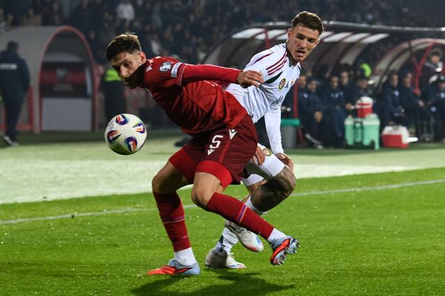 Armenia's defender #05 Styopa Mkrtchyan and Hungary's defender #14 Bendeguz Bolla vie for the ball during the FIFA World Cup 2026 qualifiers Europe zone group F football match between Armenia and Hungary at the Republican Stadium after Vazgen Sargsyan in Yerevan on November 13, 2025. (Photo by KAREN MINASYAN / AFP)