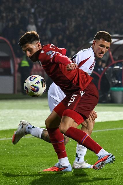 Armenia's defender #05 Styopa Mkrtchyan and Hungary's defender #14 Bendeguz Bolla vie for the ball during the FIFA World Cup 2026 qualifiers Europe zone group F football match between Armenia and Hungary at the Republican Stadium after Vazgen Sargsyan in Yerevan on November 13, 2025. (Photo by KAREN MINASYAN / AFP)