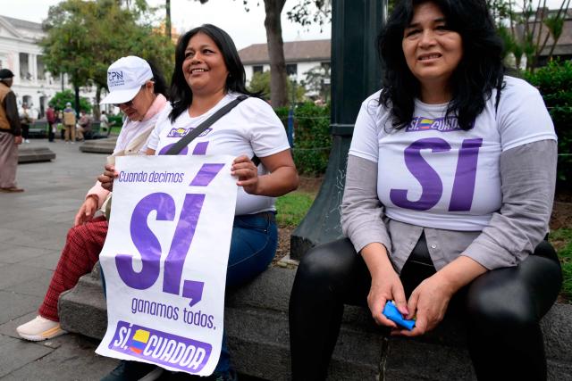 Two women take part in a gathering supporting the vote for Yes in the referendum proposed by Ecuador's President Daniel Noboa, at the Plaza Grande in Quito on November 13, 2025. On November 16, Ecuadoreans will vote in a referendum on four key issues: allowing foreign military bases, convening a constituent assembly to draft a new Constitution, eliminating state funding for political parties, and reducing the number of assembly members. (Photo by Rodrigo BUENDIA / AFP)