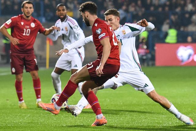 Armenia's defender #21 Nayair Tiknizyan and Hungary's defender #14 Bendeguz Bolla vie for the ball during the FIFA World Cup 2026 qualifiers Europe zone group F football match between Armenia and Hungary at the Republican Stadium after Vazgen Sargsyan in Yerevan on November 13, 2025. (Photo by KAREN MINASYAN / AFP)
