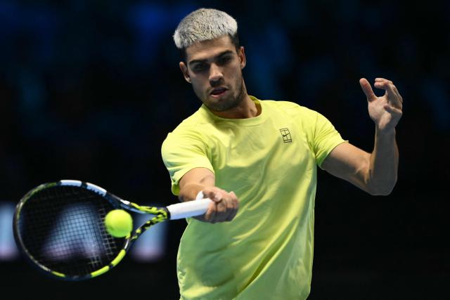 Spain's Carlos Alcaraz hits the ball during his match against Italy's Lorenzo Musetti at the ATP Finals tennis tournament in Turin on November 13, 2025. (Photo by Marco BERTORELLO / AFP)