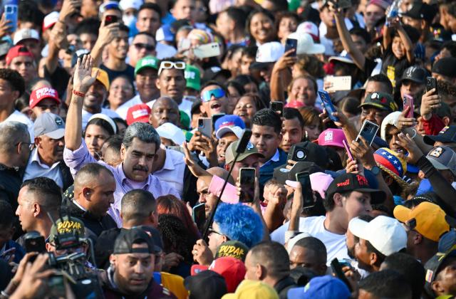 Venezuela's President Nicolas Maduro waves among people during a demonstration on Youth Day in Caracas on November 13, 2025. (Photo by Juan BARRETO / AFP)