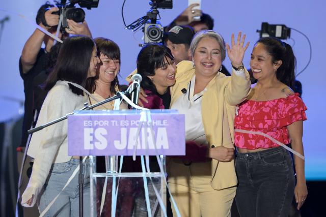 Chile's presidential candidate Jeannette Jara (2nd R) of the Unidad por Chile coalition greets supporters alongside relatives during her closing campaign rally in Valparaiso, Chile, on November 13, 2025. (Photo by Rodrigo ARANGUA / AFP)