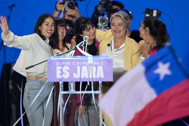 Chile's presidential candidate Jeannette Jara (2nd R) of the Unidad por Chile coalition embraces relatives during her closing campaign rally in Valparaiso, Chile, on November 13, 2025. (Photo by Rodrigo ARANGUA / AFP)