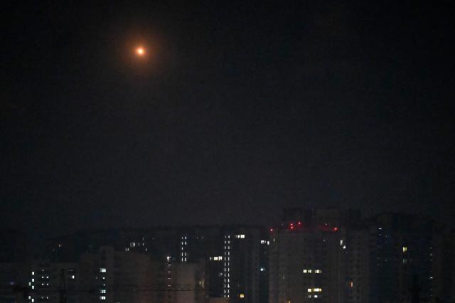 This photo shows Ukrainian air defence firing at Russian drones above Kyiv on November 14, 2025, amid the Russian invasion of Ukraine. Kyiv was under a 'massive' attack early November 14 morning, the Ukrainian capital's mayor said, with AFP journalists reporting explosions in the city. "Air defence forces are operating in Kyiv. A massive enemy attack on the capital," Vitaly Klitschko posted on Telegram, reporting two people wounded in the eastern Dniprovsky district. (Photo by Sergei SUPINSKY / AFP)