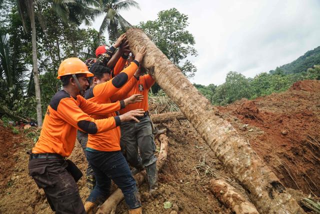 Rescuers search for survivors after a landslide buried some houses in Cibeunying village, Cilacap regency, Central Java, on November 14, 2025. A landslide killed two people and left at least 21 others missing in Indonesia, a disaster official said on November 14. (Photo by Bakhtiar RAHMAN / AFP)