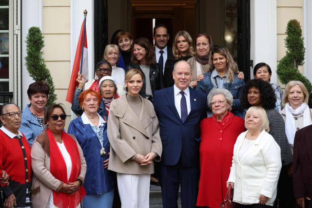 Princess Charlene of Monaco (C-L) and Prince Albert II of Monaco (C-R) pose with ederly women at the end of a charity event to distribute parcels of Red Cross to elderly people in Monaco on November 14, 2025. (Photo by Valery HACHE / AFP) / NO TABLOIDS WEB & PRINT, NO DAILY MAIL, NO DAILY MAIL GROUP, NO VOICI, NO CLOSER