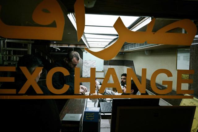 Clients stand inside a money exchange office in Beirut on November 14, 2025. Lebanon announced on November 14 that money changers and transfer companies must comply with stricter requirements as the country faces heavy US pressure to regulate its cash economy and halt financing to the militant group Hezbollah. (Photo by Joseph EID / AFP)