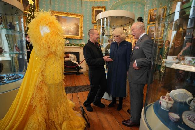 Britain's King Charles III and Britain's Queen Camilla view a fashion design with fashion designer Julien Macdonald at a celebratory reception to mark the 200th anniversary of Cyfarthfa Castle during a visit to the South Wales town of Merthyr Tydfil on November 14, 2025, on the King's 77th birthday. (Photo by Kin Cheung / POOL / AFP)
