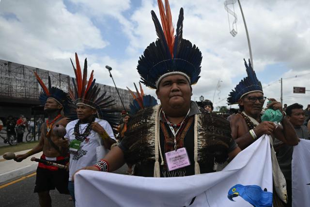 Munduruku Indigenous people of the Ipereg Ayu movement walk towards an auditorium as they demand to meet Brazilian authorities during the COP30 UN Climate Change Conference, in Belem, Para State, Brazil, on November 14, 2025. Dozens of Indigenous protesters, some holding babies, peacefully blocked the entrance to the UN climate summit in Brazil on Friday to demand a meeting with President Luiz Inacio Lula da Silva and discuss their plight in the Amazon. (Photo by Mauro PIMENTEL / AFP)