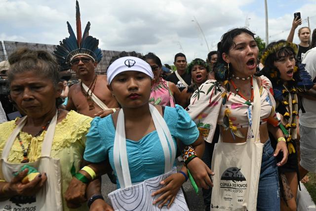 Munduruku Indigenous women of the Ipereg Ayu movement walk towards an auditorium as they demand to meet Brazilian authorities during the COP30 UN Climate Change Conference, in Belem, Para State, Brazil, on November 14, 2025. Dozens of Indigenous protesters, some holding babies, peacefully blocked the entrance to the UN climate summit in Brazil on Friday to demand a meeting with President Luiz Inacio Lula da Silva and discuss their plight in the Amazon. (Photo by Mauro PIMENTEL / AFP)