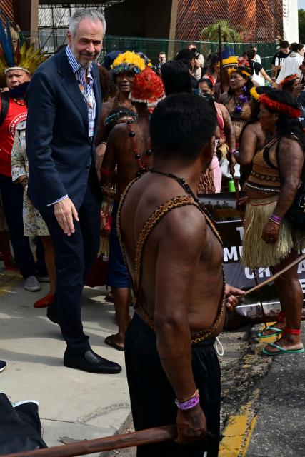 COP30 President Andre Correa do Lago speaks with Munduruku Indigenous people, members of the Ipereg Ayu movement, blocking the entrance to the COP30 UN Climate Change Conference venue, in Belem, Para State, Brazil on November 14, 2025. The group is demanding a meeting with Brazilian President Luiz Inacio Lula da Silva, who is presiding over the crucial climate negotiations in Belem at the Amazon frontier. Brazil on the eve defended security at COP30 after concerns were raised earlier this week over a separate demonstration involving members of Indigenous tribes. (Photo by Pablo PORCIUNCULA / AFP)