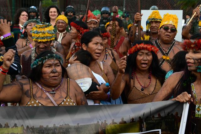 Munduruku Indigenous people, members of the Ipereg Ayu movement, shout slogans while blocking the entrance to the COP30 UN Climate Change Conference venue, in Belem, Para State, Brazil on November 14, 2025. The group is demanding a meeting with Brazilian President Luiz Inacio Lula da Silva, who is presiding over the crucial climate negotiations in Belem at the Amazon frontier. Brazil on the eve defended security at COP30 after concerns were raised earlier this week over a separate demonstration involving members of Indigenous tribes. (Photo by Pablo PORCIUNCULA / AFP)
