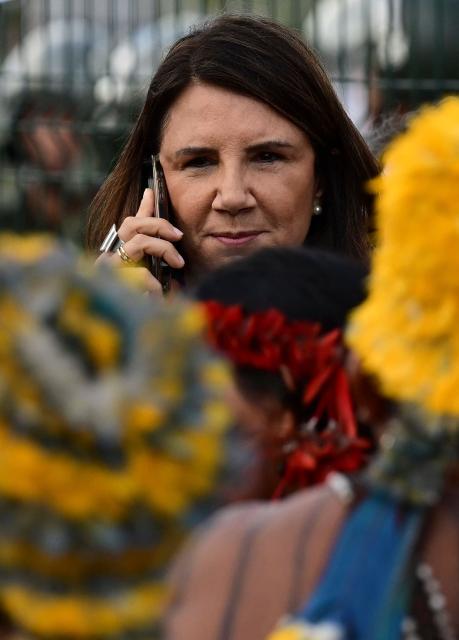 Brazil's COP30 executive director Ana Toni Sspeaks on her mobile phone as Munduruku Indigenous people, members of the Ipereg Ayu movement, block the entrance to the COP30 UN Climate Change Conference venue, in Belem, Para State, Brazil on November 14, 2025. The group is demanding a meeting with Brazilian President Luiz Inacio Lula da Silva, who is presiding over the crucial climate negotiations in Belem at the Amazon frontier. Brazil on the eve defended security at COP30 after concerns were raised earlier this week over a separate demonstration involving members of Indigenous tribes. (Photo by Pablo PORCIUNCULA / AFP)