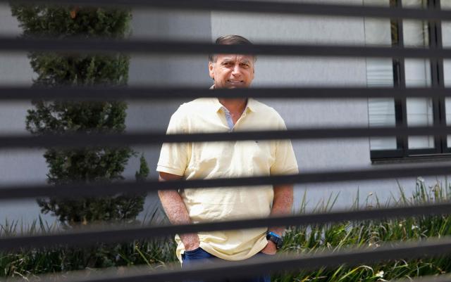 (FILES) Former Brazilian President Jair Bolsonaro gestures from his residence in Brasilia on September 3, 2025. Brazil's far-right former president Jair Bolsonaro is running out of options to avoid prison, with judges on November 14, 2025 set to reject his appeal against a 27-year sentence for a botched coup bid. (Photo by Sergio Lima / AFP)
