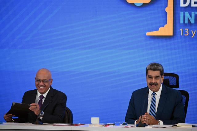 Venezuela's President Nicolas Maduro (R) smiles next to National Assembly President Jorge Rodriguez during the Meeting of Jurists in Defense of International Law at the Eurobuilding Hotel in Caracas on November 14, 2025. (Photo by Federico PARRA / AFP)