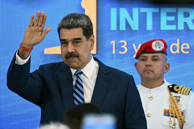 Venezuela's President Nicolas Maduro waves during the Meeting of Jurists in Defense of International Law at the Eurobuilding Hotel in Caracas on November 14, 2025. (Photo by Federico PARRA / AFP)
