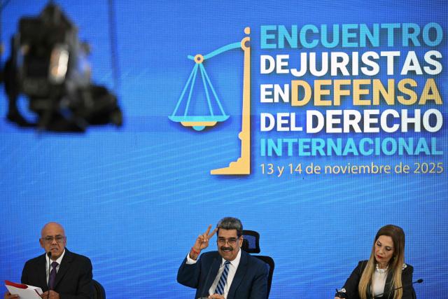 Venezuela's President Nicolas Maduro (C) makes a victory sign next to National Assembly President Jorge Rodriguez (L) and Supreme Court of Justice President Caryslia Rodriguez during the Meeting of Jurists in Defense of International Law at the Eurobuilding Hotel in Caracas on November 14, 2025. (Photo by Federico PARRA / AFP)