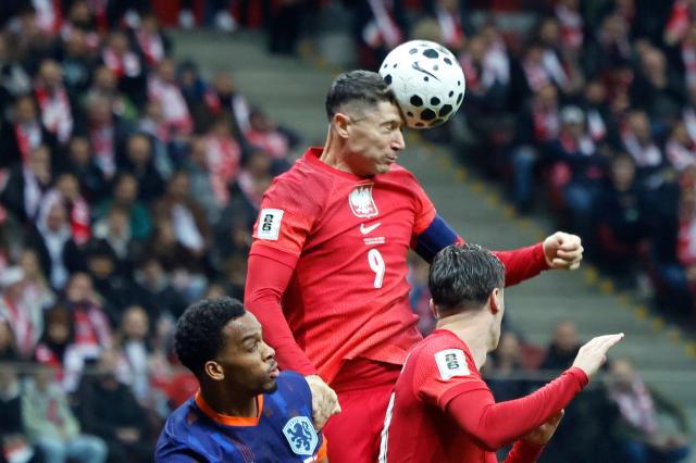 Poland's forward #09 Robert Lewandowski (C) heads the ball during the 1st round - day 9 - Group G World Cup 2026 European Qualifiers football match between Poland and the Netherlands on November 14, 2025 in Warsaw, Poland. (Photo by Wojtek RADWANSKI / AFP)