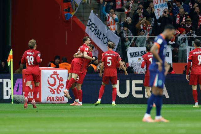 Poland's midfielder #13 Jakub Kaminski (2nd L) is celebrated by team mates after scoring the 1-0 goal during the 1st round - day 9 - Group G World Cup 2026 European Qualifiers football match between Poland and the Netherlands on November 14, 2025 in Warsaw, Poland. (Photo by Wojtek RADWANSKI / AFP)