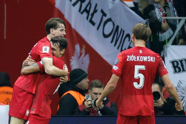 Poland's midfielder #13 Jakub Kaminski (L) is celebrated by team mates after scoring the 1-0 goal during the 1st round - day 9 - Group G World Cup 2026 European Qualifiers football match between Poland and the Netherlands on November 14, 2025 in Warsaw, Poland. (Photo by Wojtek RADWANSKI / AFP)