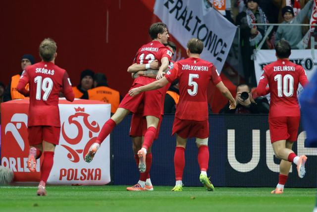 Poland's midfielder #13 Jakub Kaminski (2nd L) is celebrated by team mates after scoring the 1-0 goal during the 1st round - day 9 - Group G World Cup 2026 European Qualifiers football match between Poland and the Netherlands on November 14, 2025 in Warsaw, Poland. (Photo by Wojtek RADWANSKI / AFP)