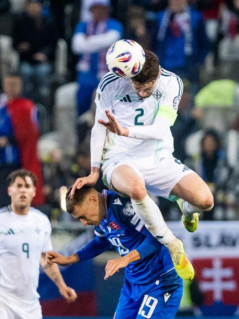 Slovakia's midfielder #19 Tomas Rigo (bottom) and Northern Ireland's defender #02 Conor Bradley (top) vie for the ball during the World Cup 2026 European Qualifiers football match between Slovakia and Northern Ireland on November 14, 2025 in Kosice, Slovakia. (Photo by Branislav Racko / AFP)
