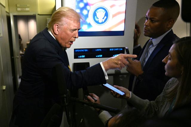 TOPSHOT - US President Donald Trump points as he speaks to reporters aboard Air Force One en route to Palm Beach, Florida, on November 14, 2025. Trump is headed to his Mar-a-Lago, Florida, residence where he will spend the weekend. (Photo by Jim WATSON / AFP)