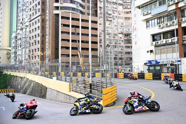 Riders take the Melco hairpin at the start of the 57th Macau Motorcycle Grand Prix in Macau on November 15, 2025. (Photo by Peter PARKS / AFP)