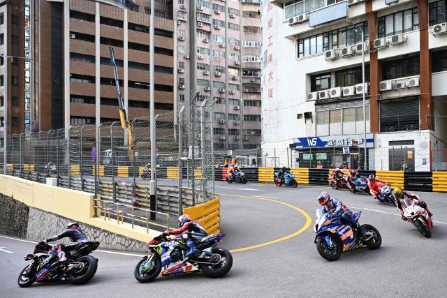 Riders take the Melco hairpin at the start of the 57th Macau Motorcycle Grand Prix in Macau on November 15, 2025. (Photo by Peter PARKS / AFP)