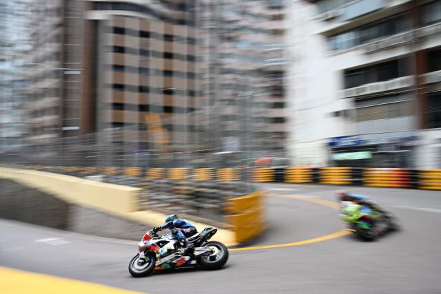 Riders take the Melco hairpin at the start of the 57th Macau Motorcycle Grand Prix in Macau on November 15, 2025. (Photo by Peter PARKS / AFP)