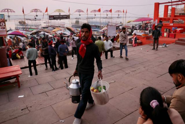 A vendor sells tea at Dashashwamedh ghat along the banks of river Ganges in Varanasi on November 15, 2025. (Photo by Niharika KULKARNI / AFP)