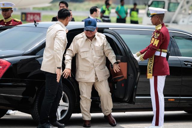 Indonesia’s President Prabowo Subianto (C) gets out of the car he arrived in together with Jordan's King Abdullah II to see him off at Halim Perdanakusuma Air Force Base in Jakarta on November 15, 2025. (Photo by YASUYOSHI CHIBA / AFP)