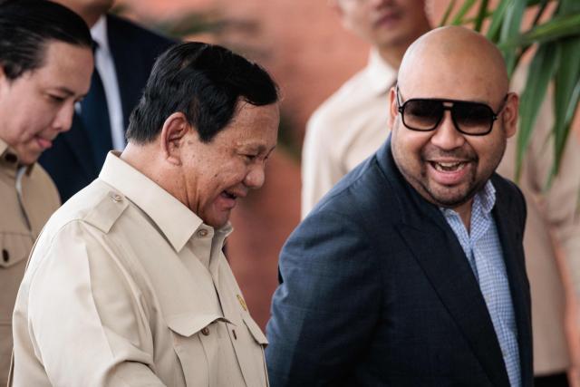 Indonesia’s President Prabowo Subianto (L) speaks with his son Didit Hediprasetyo (R) after seeing off Jordan's King Abdullah II at Halim Perdanakusuma Air Force Base in Jakarta on November 15, 2025. (Photo by YASUYOSHI CHIBA / AFP)